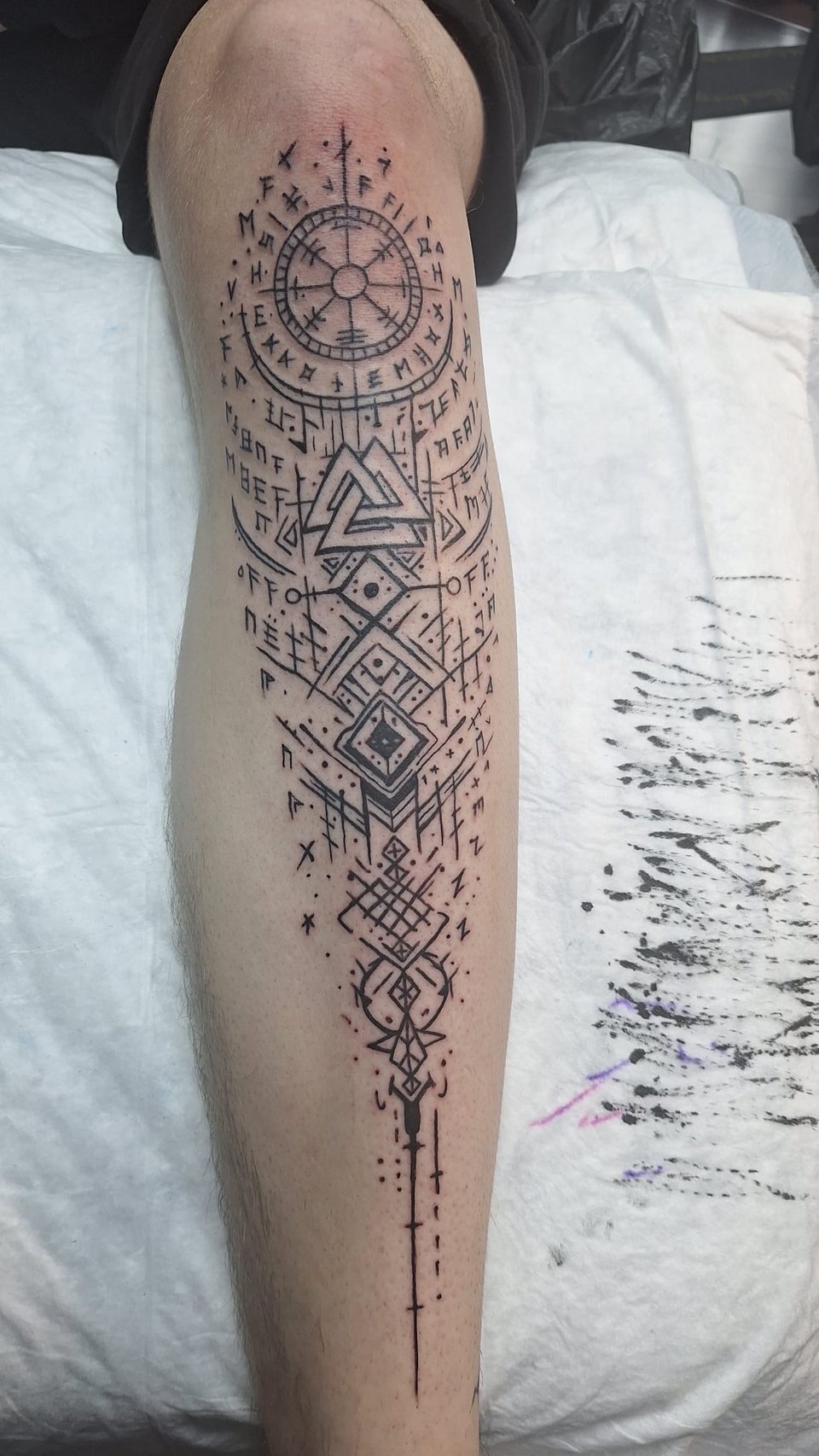 Geometrisches Dotwork-Tattoo mit Runen, Vegvisir und Valknut an der Wade