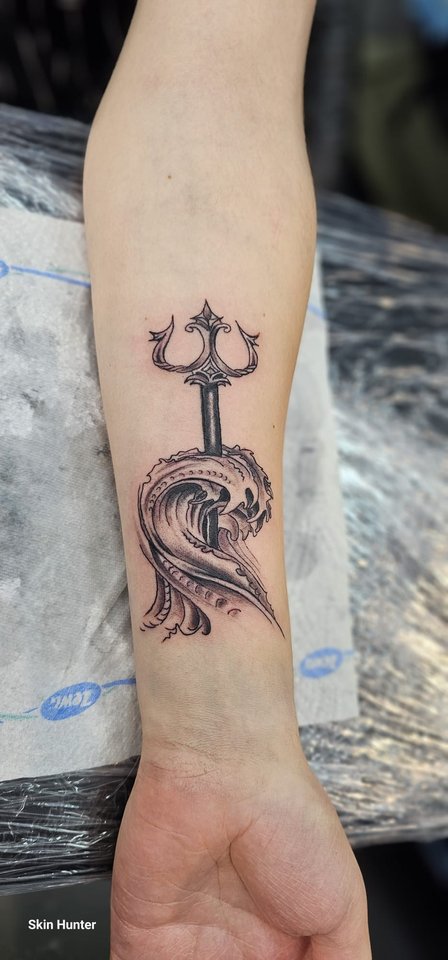 Fertiges Tattoo eines Dreizacks mit Welle am Unterarm