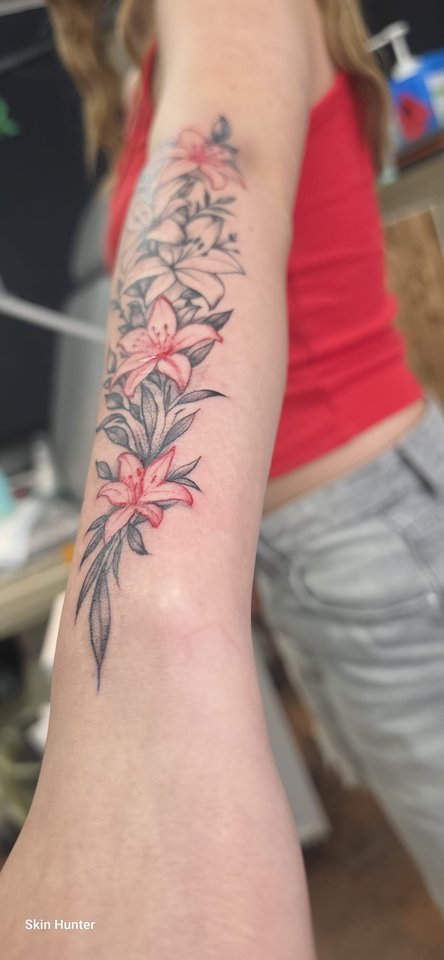 Farbige Lilien und Blüten in Rosa am Unterarm