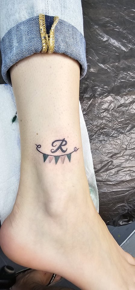 Kleiner Buchstabe mit Wimpelkette am Knöchel