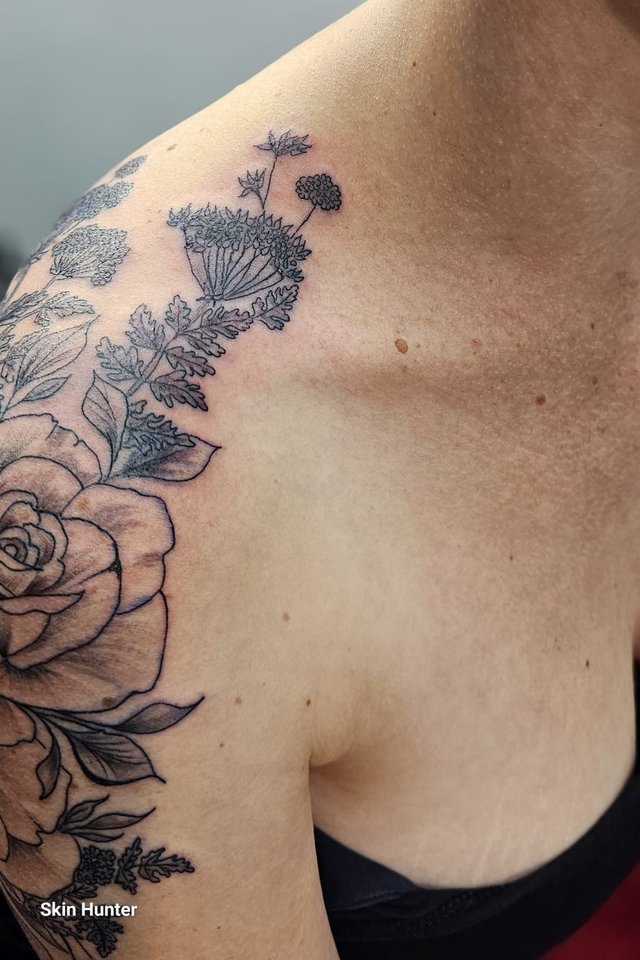 Florales Tattoo mit Rosen und Blättern über Schulter und Rücken