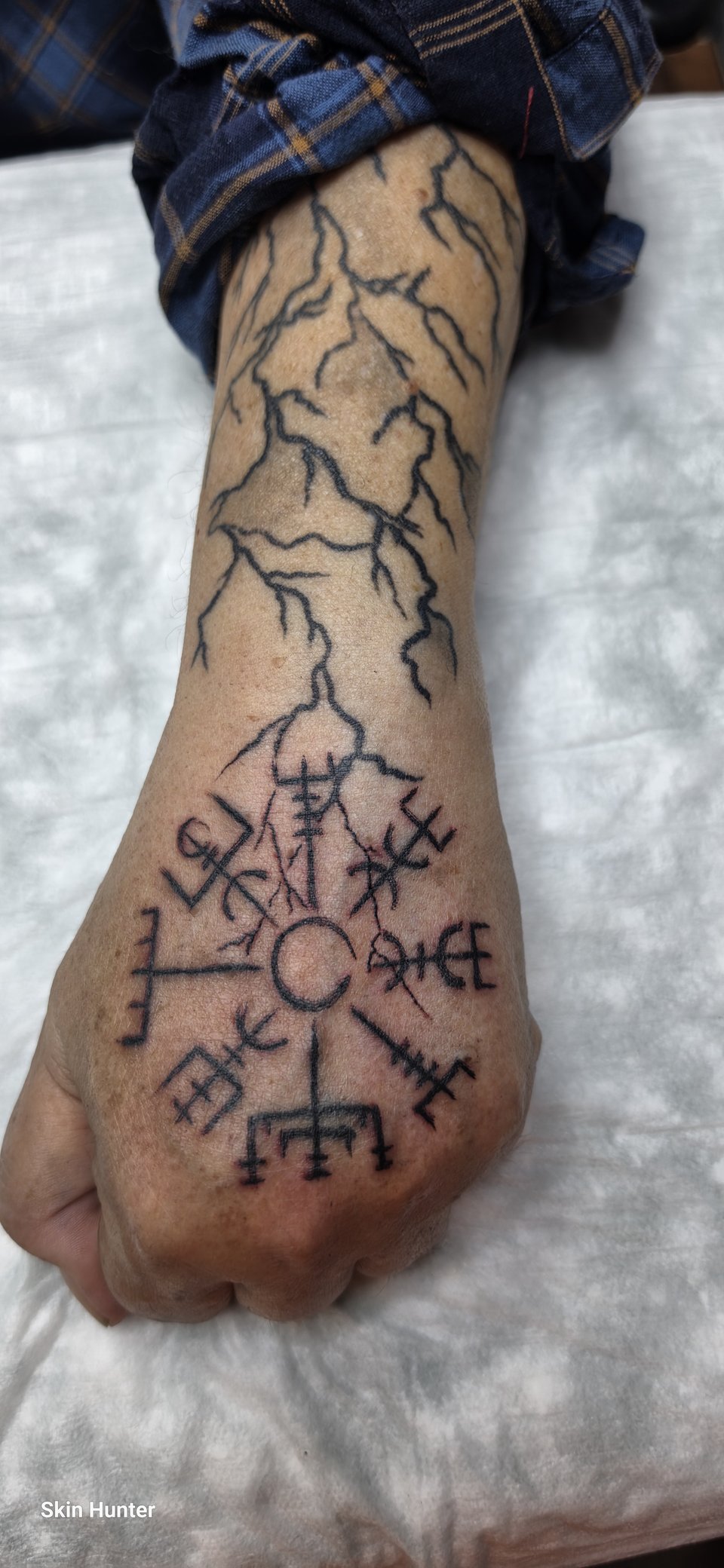 Vegvisir auf dem Handrücken, darüber Blitze am Unterarm