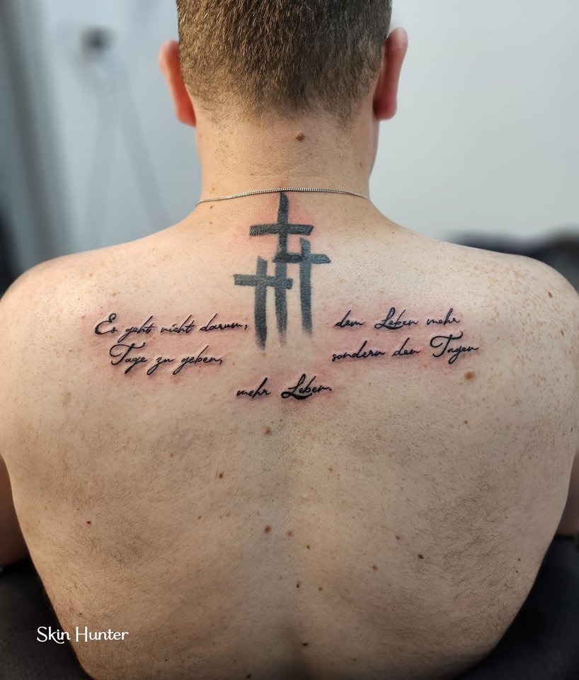 Kreuze mit Schriftzeilen zwischen den Schulterblättern