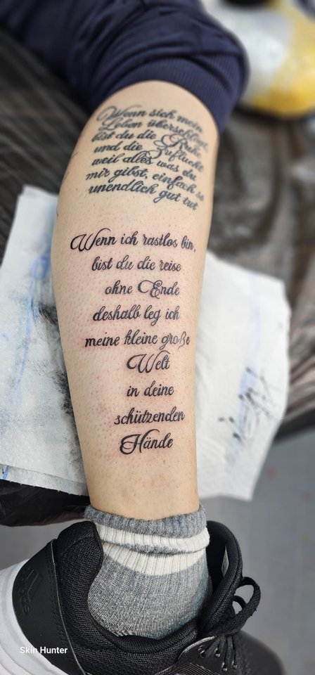 Mehrzeiliger Text in Schreibschrift an der Wade