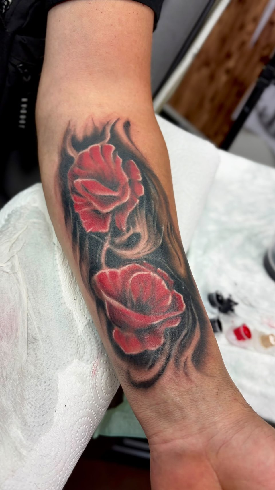 Rote Rosen mit schwarzen Schatten am Unterarm